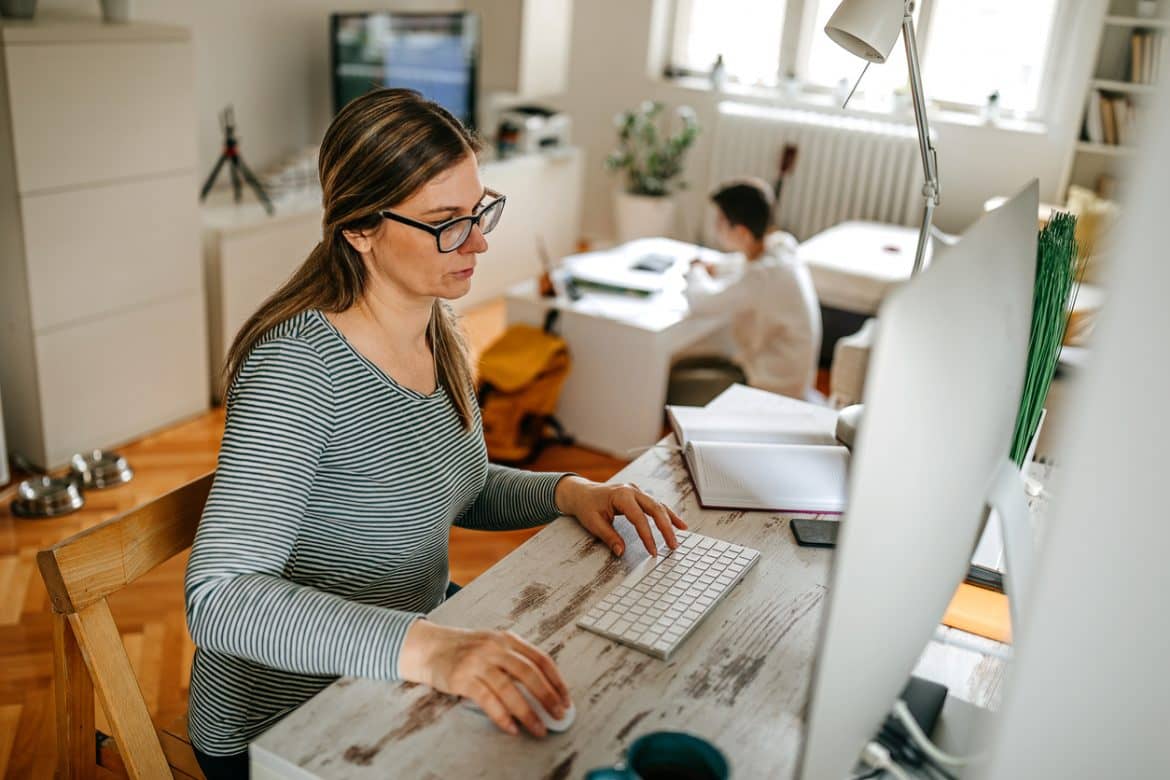 Woman sitting at computer at home reading about working from home tips for success