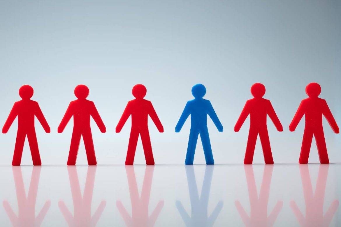 Line of red plastic human figures with one blue, representing a buyer persona or ideal customer