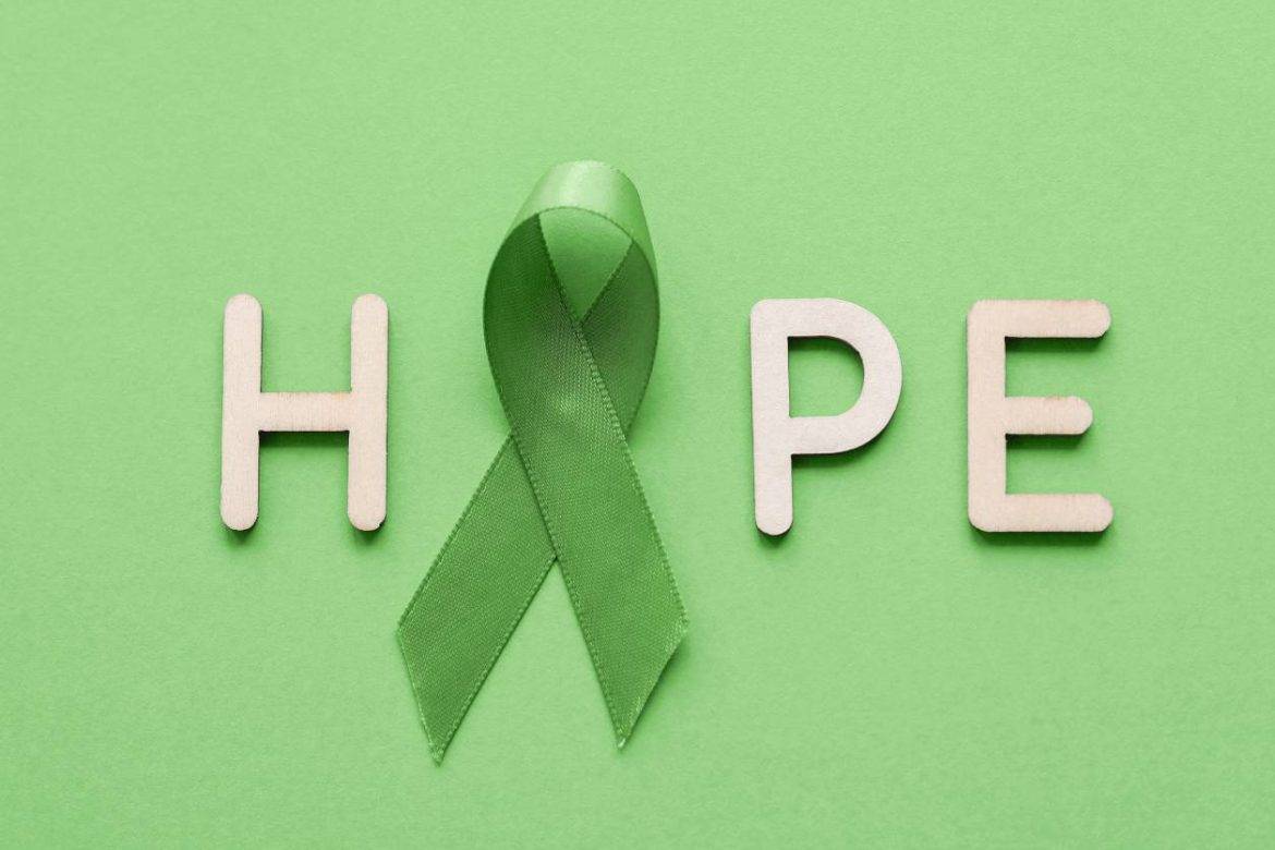 Wooden letters spelling HOPE with green ribbon as the O to represent Mental Health Awareness Month