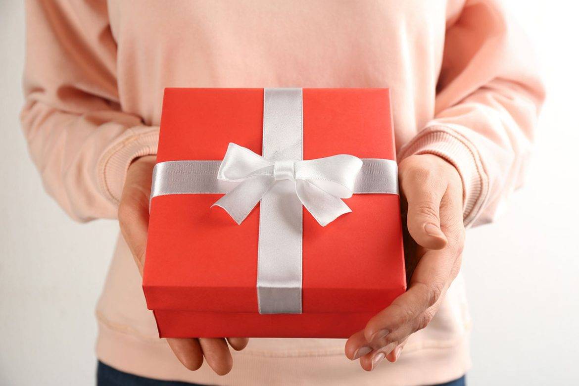 A close up of a person holding a holiday gift