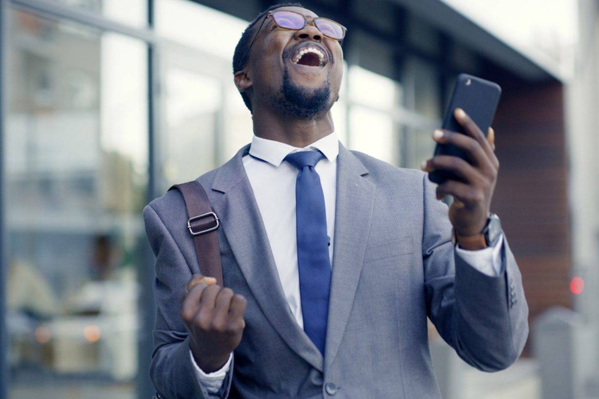 An excited man holding a cell phone