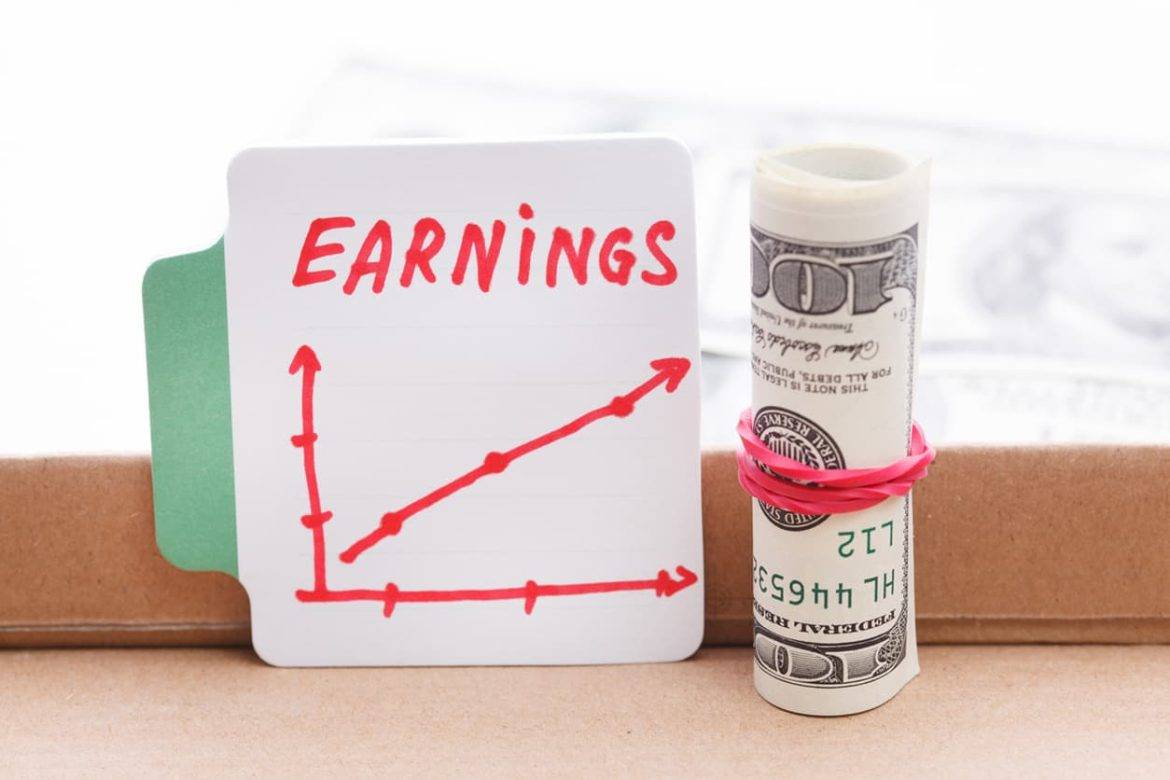 An earnings graphic that is going up and a rolled money